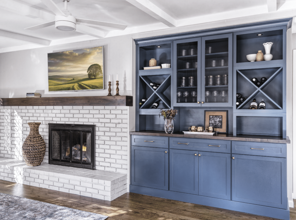 Den renovation featuring custom built-in cabinets with shelving and a mounted television.