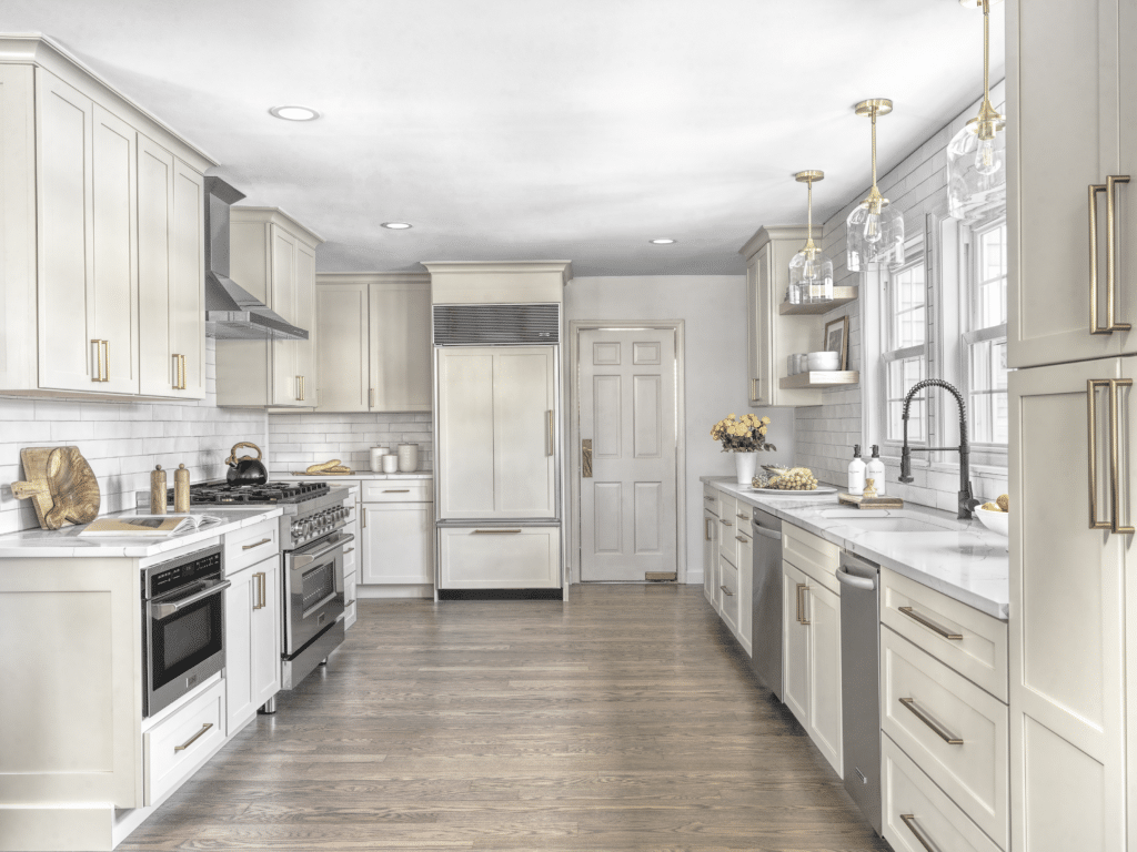 Upscale kitchen renovation with stainless steel appliances, white subway tile, and quartz countertops.