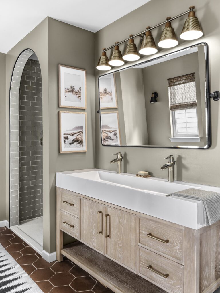 St. Charles bathroom featuring an arched shower entry, terracotta hexagon tiles, and a white trough sink vanity.